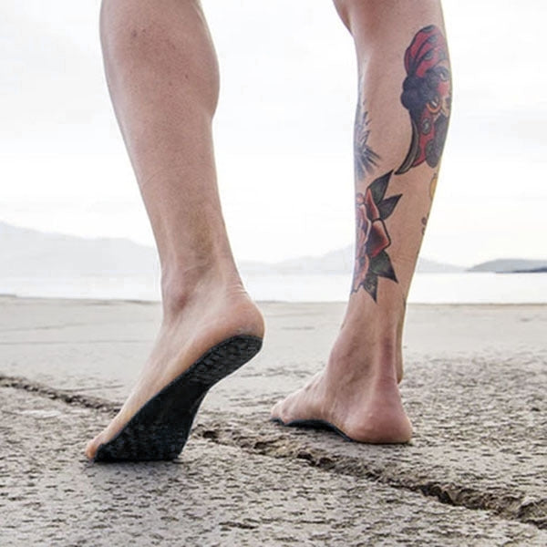 Black anti-slip sandal insole under foot, dotted grip texture for beach wear
