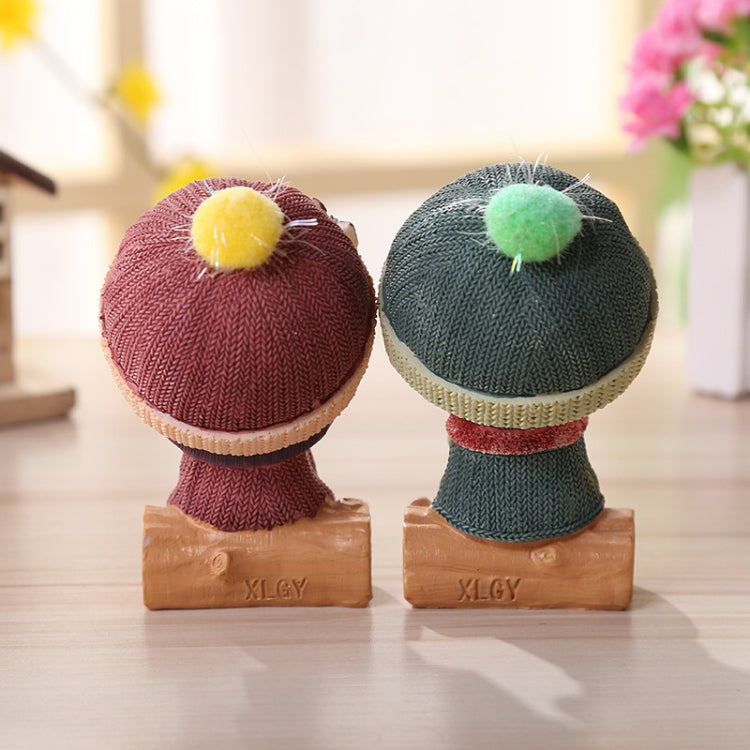 Resin doll figurines on bases, knit hats with pom-poms and red trim, brown shoes
