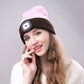 Brown knit winter beanie with glowing side LED light patch on a person