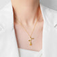 Gold-tone rose pendant necklace on model with branching floral charm and leaf accents