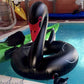 Black swan inflatable pool float ring with red beak and curled tail