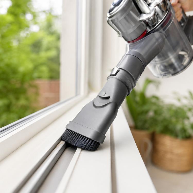 Dual-purpose vacuum brush head with hard bristles on a gray extension nozzle