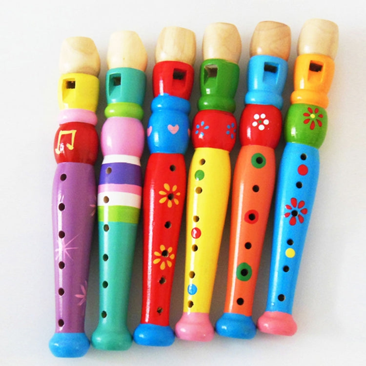 Colorful wooden toy flute set standing together, painted patterns and finger holes