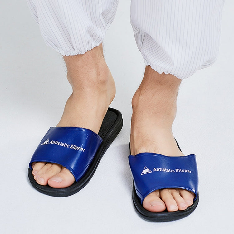 Blue open-toe PVC slippers on feet with white striped pants