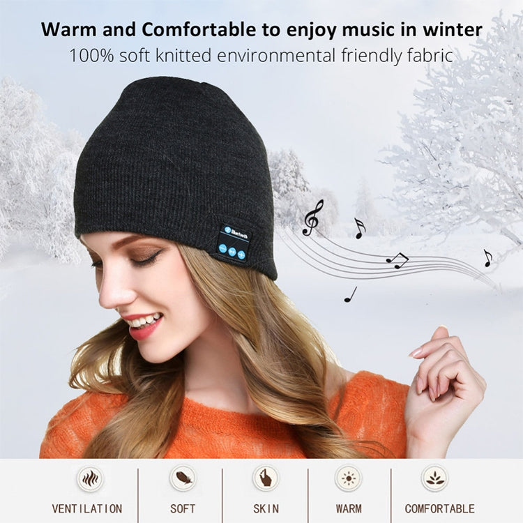 Black knit beanie with Bluetooth control panel patch, worn on a woman’s head.