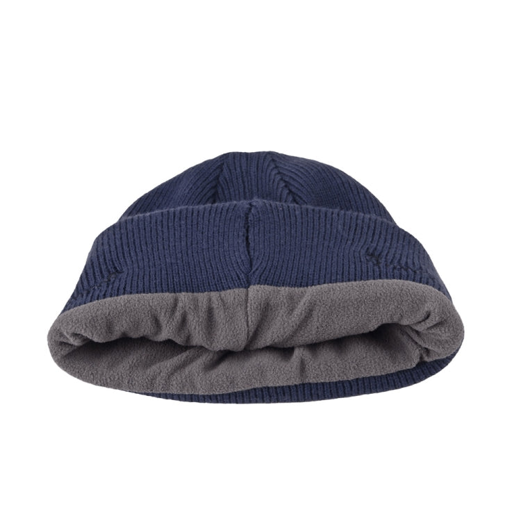 Navy blue beanie with folded cuff showing gray underside and brown control patch