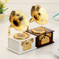 Two gold-tone phonograph-style music boxes on white and dark bases with horns