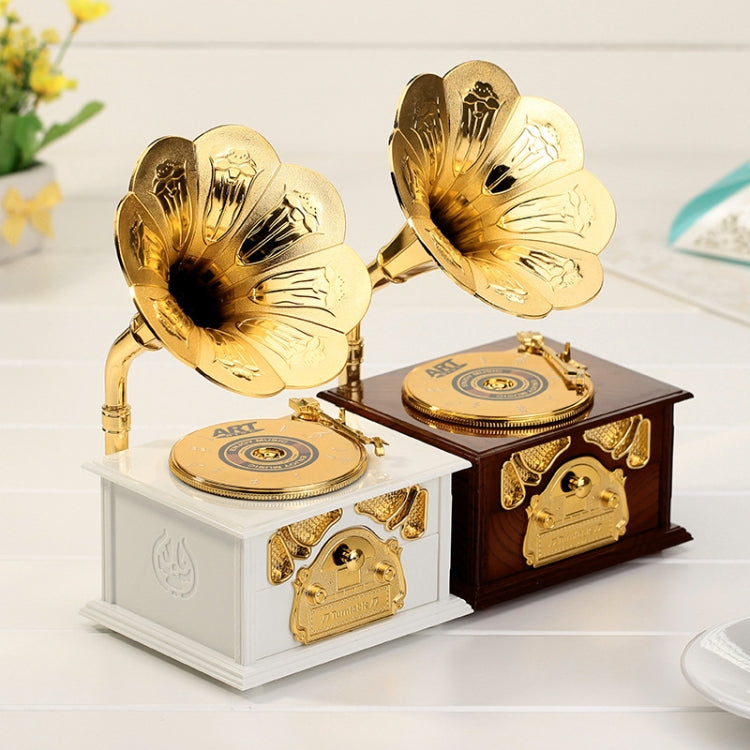 Two gold-tone phonograph-style music boxes on white and dark bases with horns