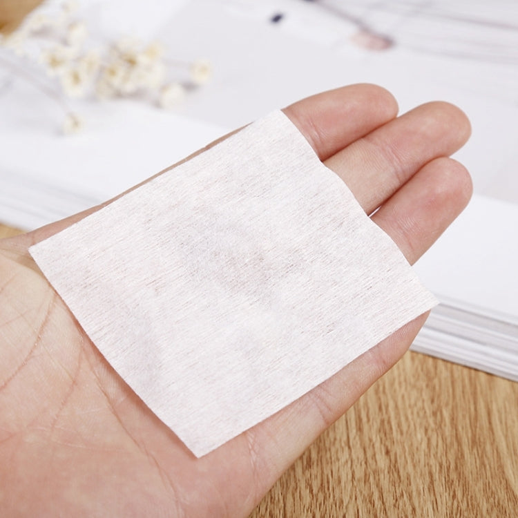 Soft disposable facial cotton puff pad held in hand
