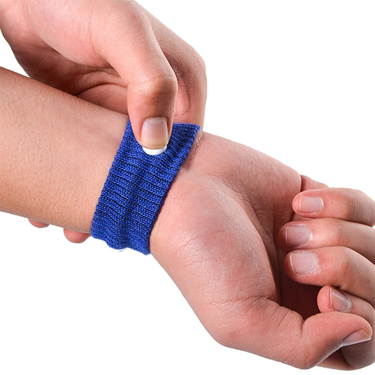 Blue knit wristband being worn on wrist, fastened with a round white plastic button.