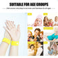 Yellow anti-nausea wrist strap with round white button worn on a hand.