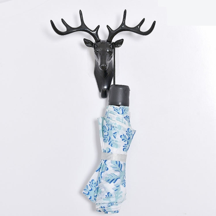 Dark deer head wall hook holding a gray-capped hanging cloth with blue pattern