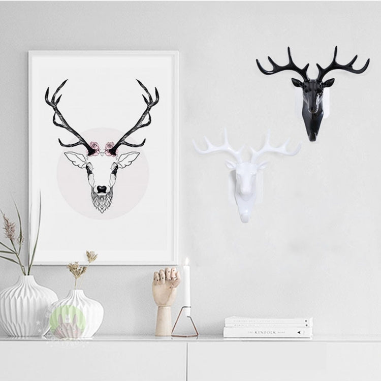 Dark deer head wall hook with four antlers, holding a blue patterned cloth