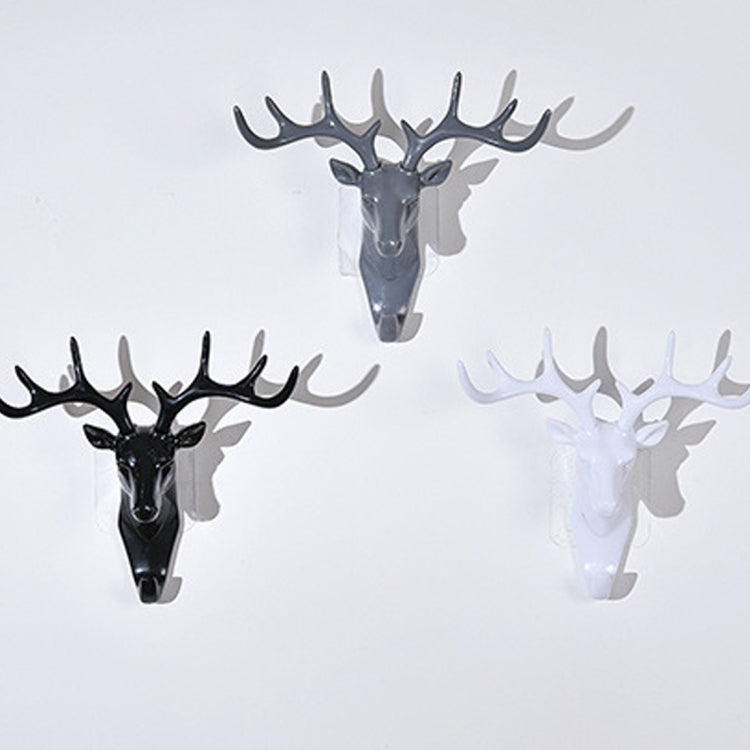 Three deer head wall hooks in dark, gray, and white with four antlers