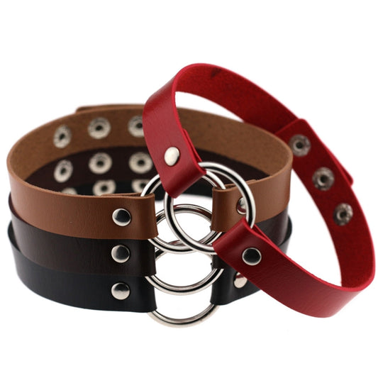 Leather collar bracelets in brown, black, and red with metal rings and studs