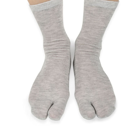 Pair of light gray two-toe socks with split toe, worn