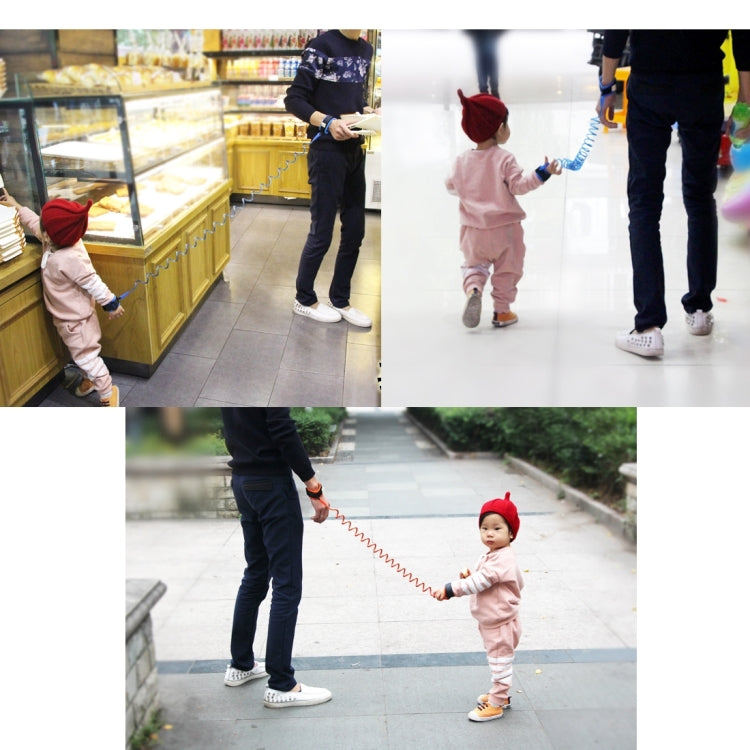 Blue spring coiled anti-lost leash connecting adult and toddler wrist cuffs.