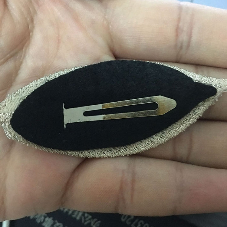 Leaf hairpin clip detail: metallic glitter edge with gold-toned clasp on black base