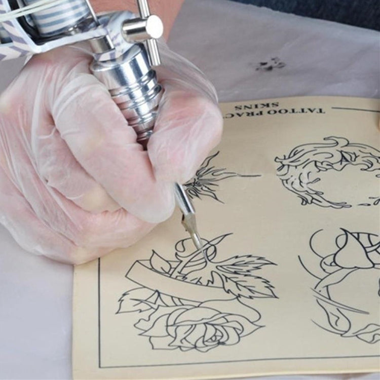 Blank silicone tattoo practice skin being outlined with tattoo tool