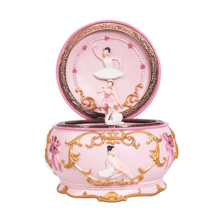 Pink rotating music box with ballerina figure under domed glass lid
