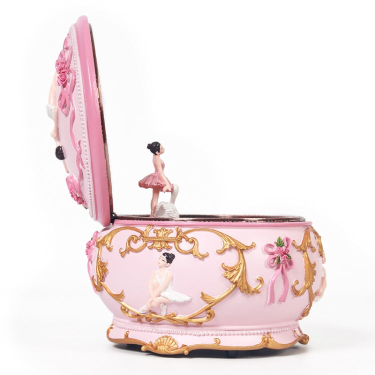 Pink ballerina music box with gold filigree trim and open rotating compartment