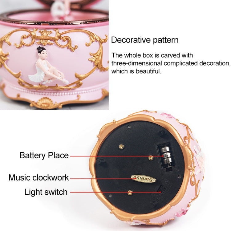 Underside of pink music box showing battery compartment, clockwork, and switch