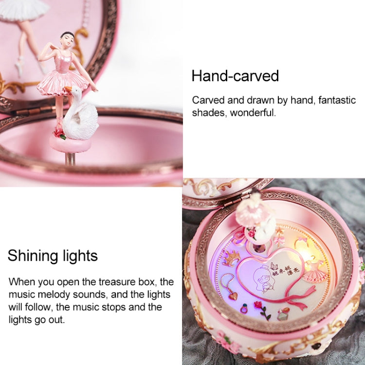 Open pink music box with hand-carved ballerina scene and glowing interior lights