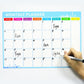 Monthly planner magnetic whiteboard being written on with marker, blue printed grid