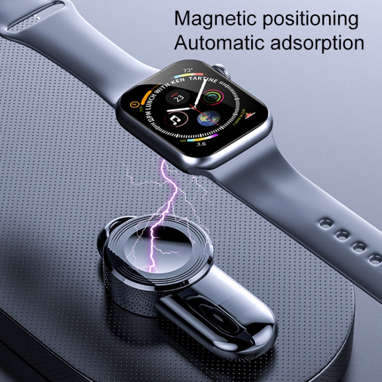Black magnetic wireless watch charger docked to a watch on a textured surface