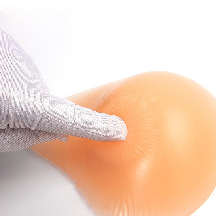 Left silicone breast pad being fitted by a hand over a white socked sleeve