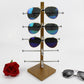 Grain wood sunglasses display stand with horizontal metal arms holding 6 pairs of shades