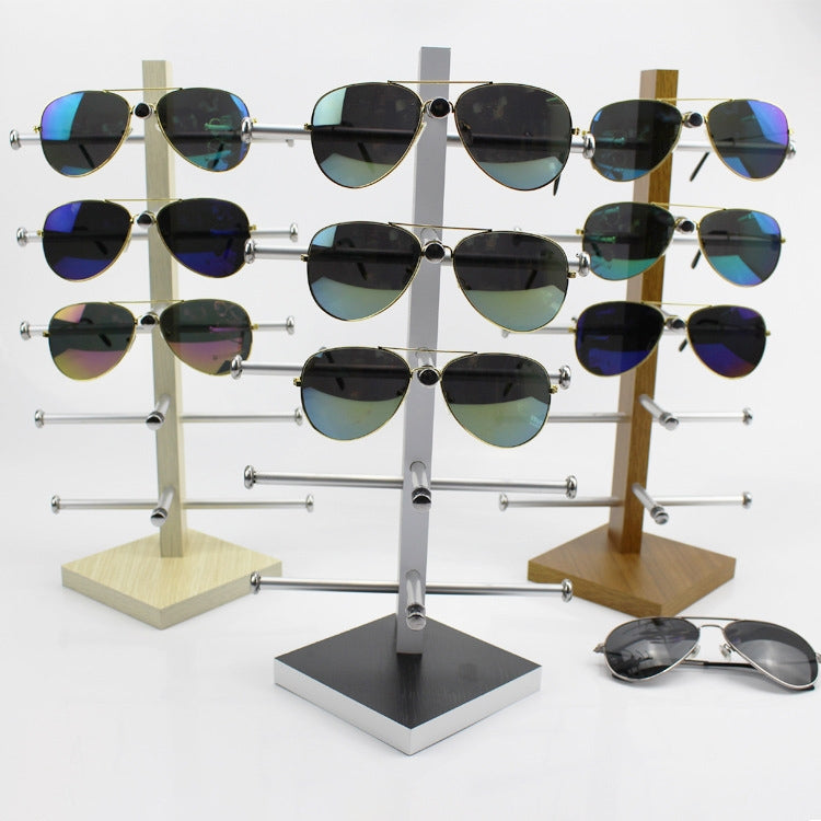 Wood sunglasses display rack with multiple metal arms on bases, holding many pairs of shades