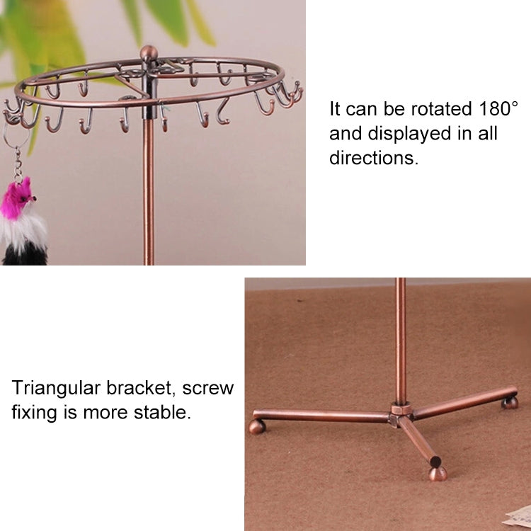 Rose gold rotating jewelry stand with top hooks and tassel-style hanging accessories