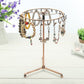 Rose gold rotating jewelry display stand with many hanging necklaces and charms