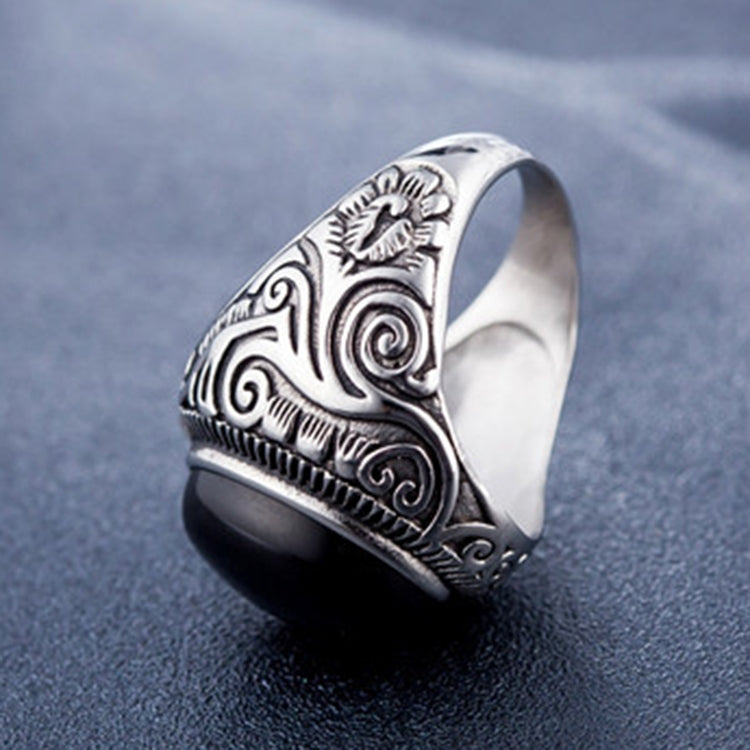 Men’s oval black-stone ring with engraved silver swirl band, open-side view