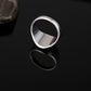 Silver-tone drip signet ring with black oval face, top view