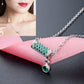 Silver chain necklace with rectangular green crystal bar pendant and round green drop charm