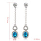 Silver-plated dangling earrings with blue crystal teardrop centers and clear stone details