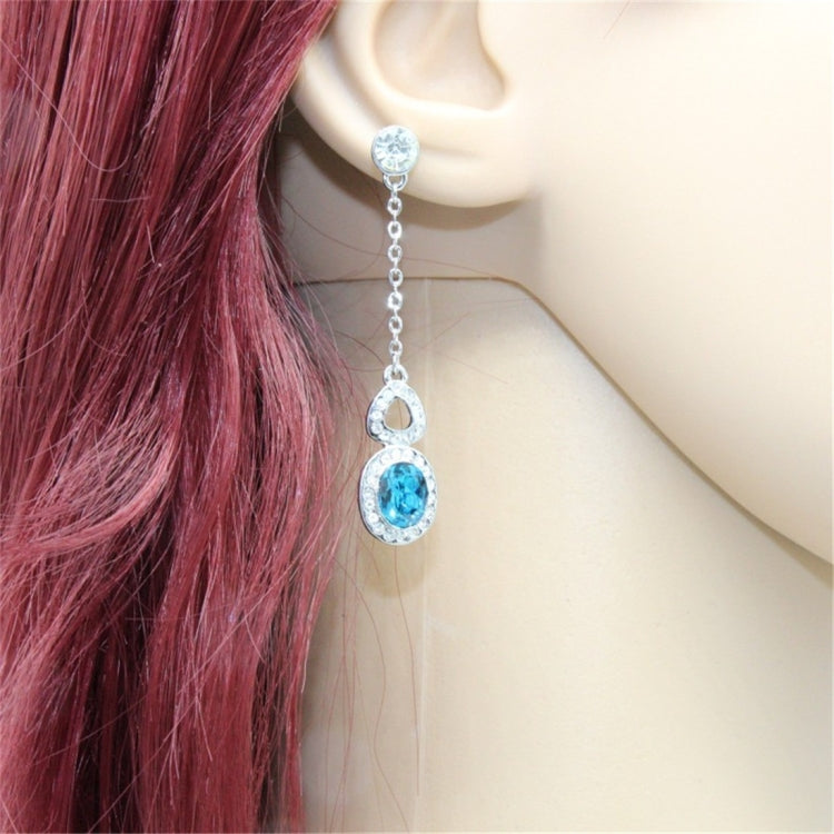Silver-plated blue crystal drop earrings shown worn with clear top stones on chains