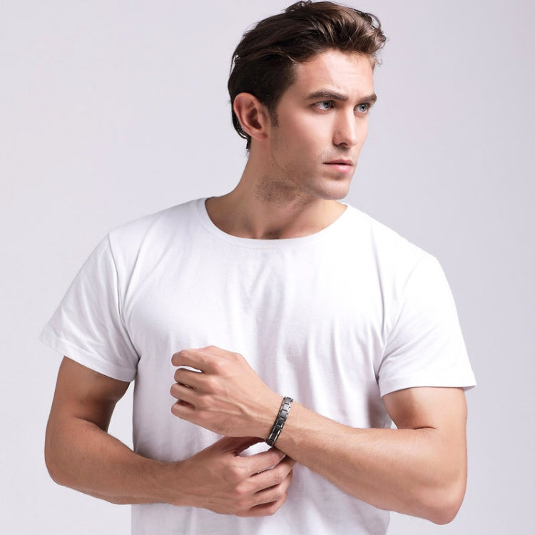 Men's titanium steel magnetic therapy bracelet on wrist with dark-tone link band