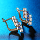 Rose gold-tone crystal cluster stud earrings with blue stones and hinged back