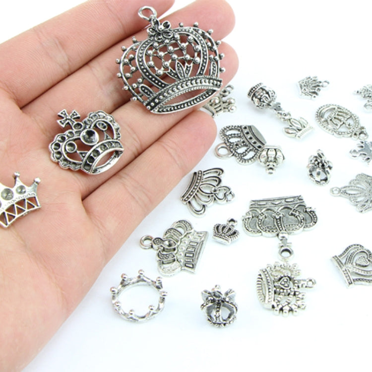 Crown pendants and charms held in an open hand, silver-toned alloy set