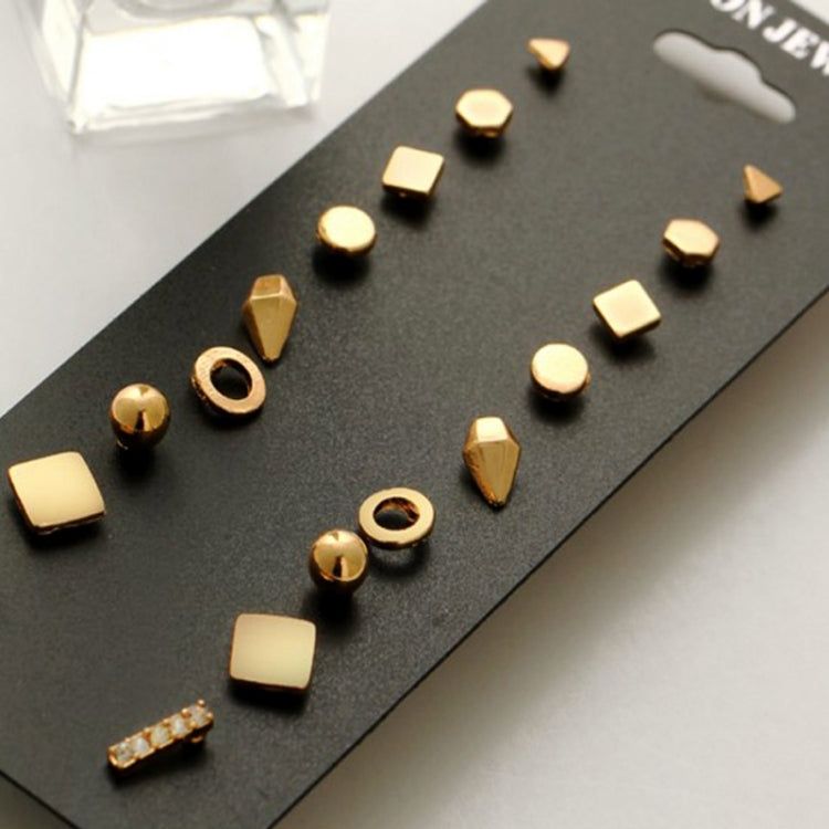 Close-up of gold-tone stud earring set with nine geometric studs on display card