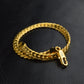 Gold braided bracelet with 18k charm and small loop clasp, angled view