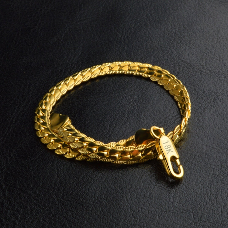 Gold braided bracelet with 18k charm and small loop clasp, angled view