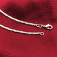 Silver tone anklet chain with clasp and small rings, close-up