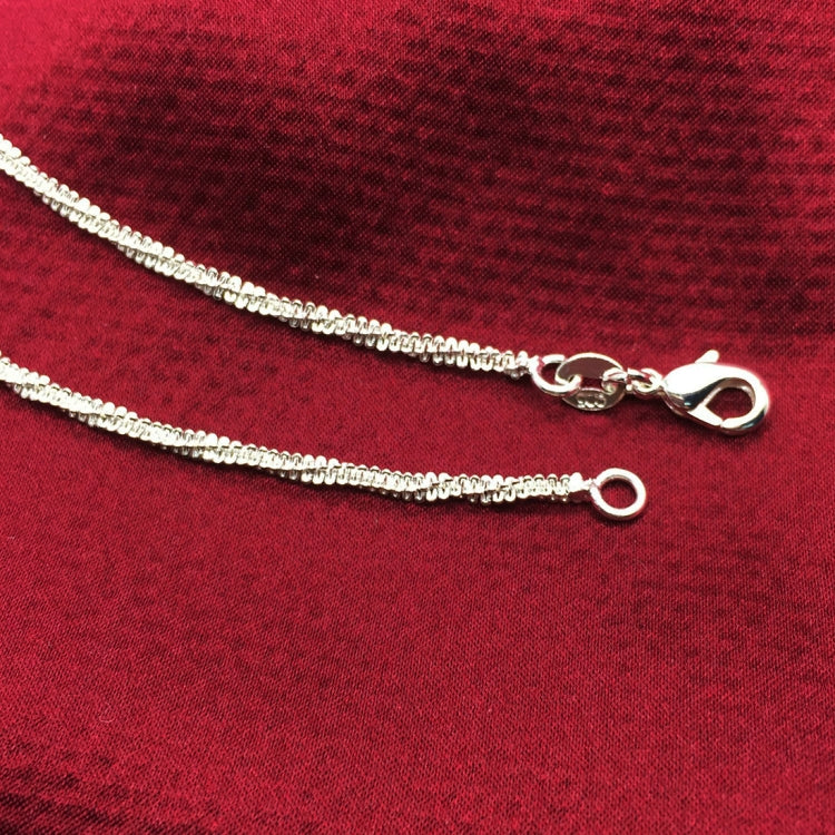 Silver tone anklet chain with clasp and small rings, close-up
