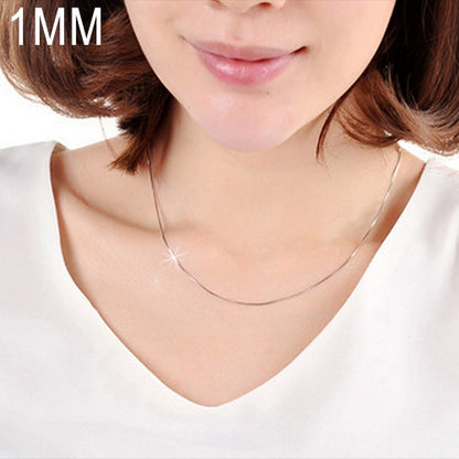 Silver snake-bone chain necklace worn with a V-neck top