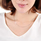 Silver snake-bone chain necklace, 2mm width, draped across the neckline