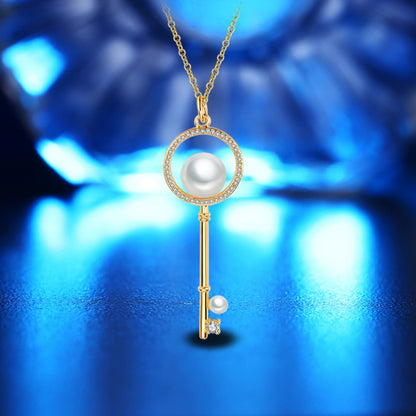 Gold key pendant necklace with round pearl, crystal halo, and dangling key charm